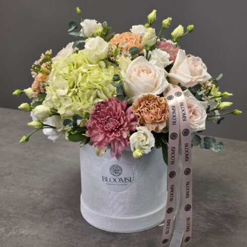Pastel Garden in Bloom luxury pastel flower arrangement in white BLOOMSI velvet hat box with roses, hydrangea and chrysanthemums