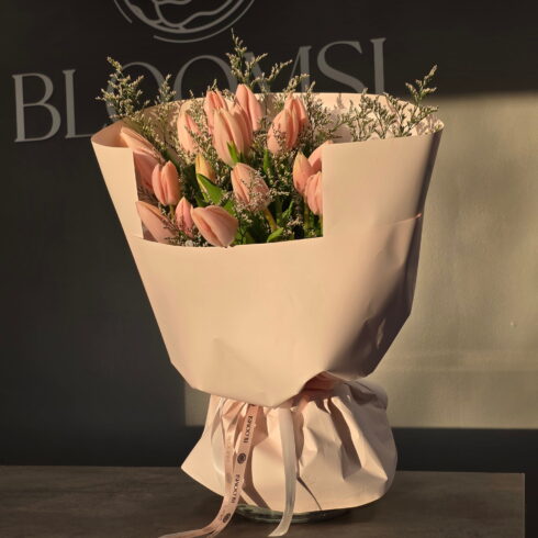 Blush pink tulip bouquet with delicate greenery wrapped in pastel paper by BLOOMSI
