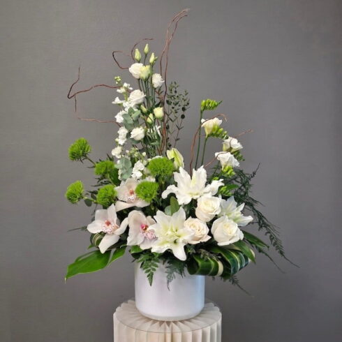 traditional funeral flower arrangement with white orchids lilies and roses Oakville