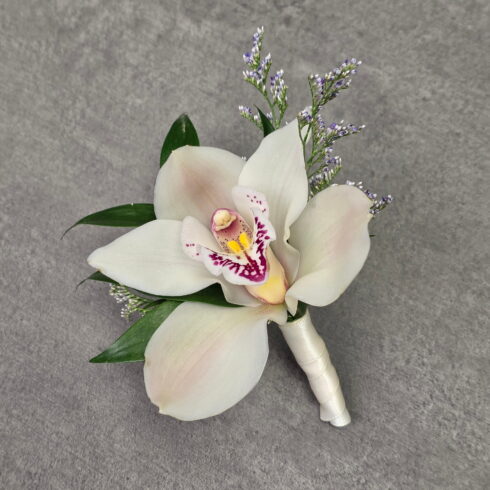 Luxury white orchid boutonniere handcrafted by BLOOMSI for weddings, prom, graduation, and special events