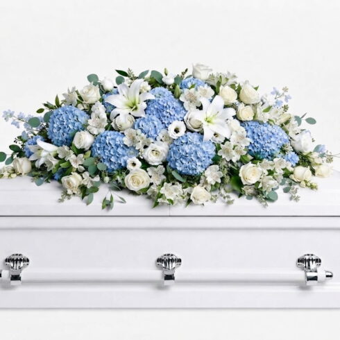 Luxury blue and white casket spray with hydrangeas white roses lilies and eucalyptus by Bloomsi