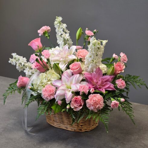 Luxury pink and white funeral basket arrangement with roses lilies hydrangeas carnations and greenery by Bloomsi