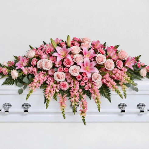 Luxury pink casket spray with pink lilies blush roses carnations and greenery by Bloomsi